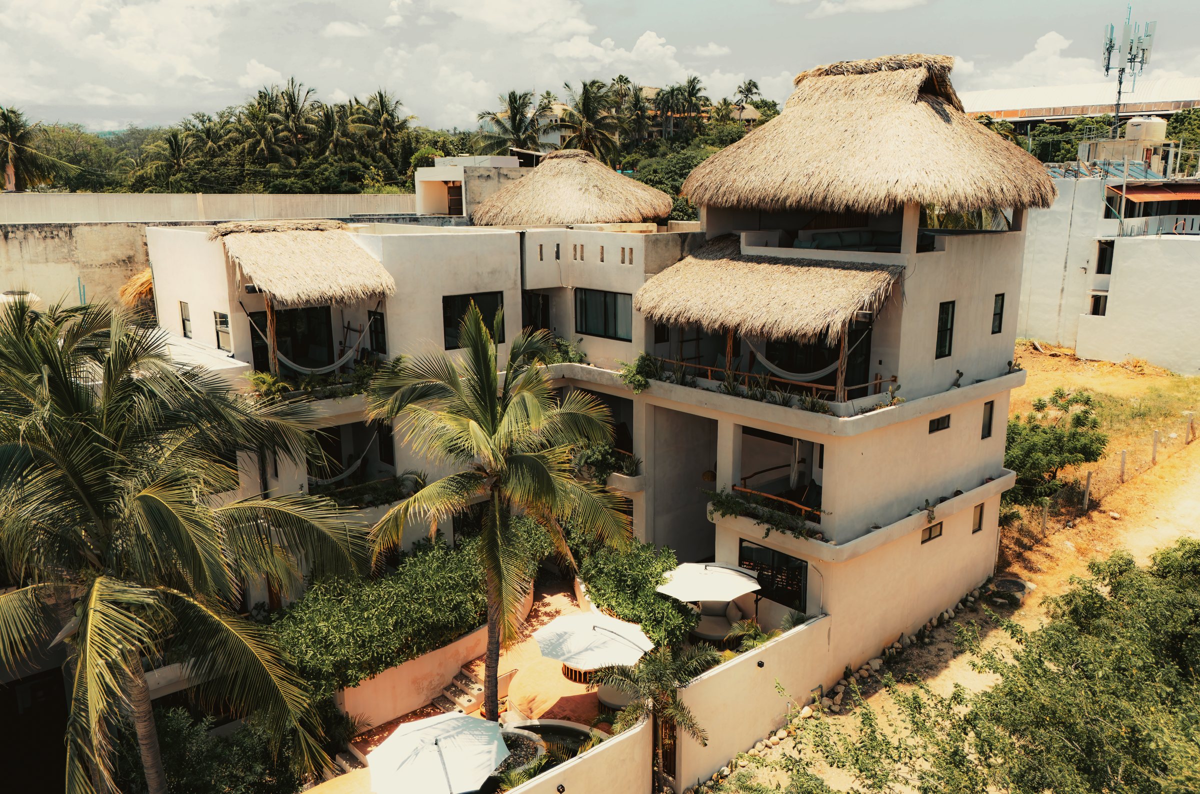 Casa Leah vista desde el aire, con palapas y palmas